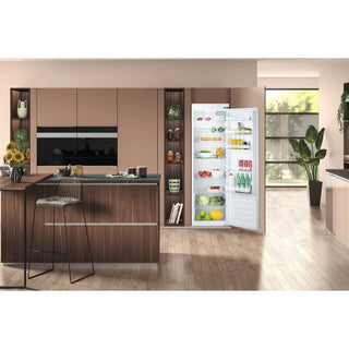 Modern kitchen with wooden cabinets and a refrigerator displaying various items.