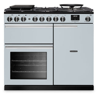 A light blue freestanding range cooker with black glass cooktop, multiple control knobs, a lower oven door with a window, and a right-side storage compartment, shown on a plain white background.