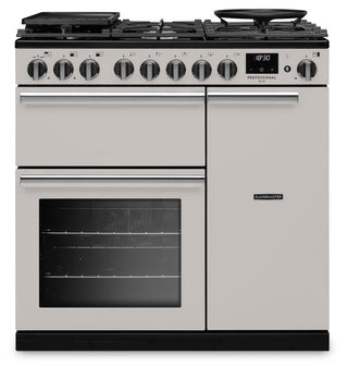 A freestanding gas range cooker in a light champagne-gold finish with black knobs, a black glass oven window, and black burner grates, shown against a plain white background.