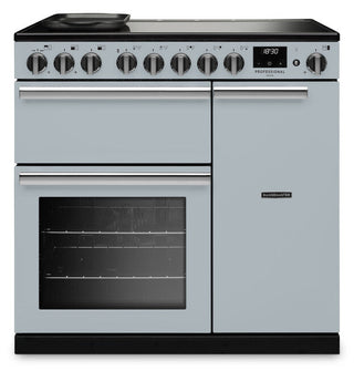 A freestanding range cooker in a light blue finish with black glass cooktop and oven windows, silver handles, and a row of control knobs on the front panel.