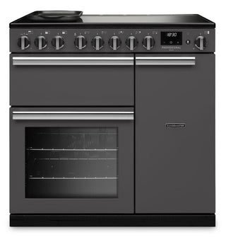 A dark gray freestanding range cooker with a black glass cooktop, multiple control knobs, a lower oven door with a window, and a right-side storage cabinet, shown on a plain white background.