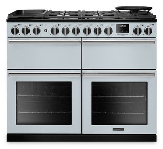 A stainless steel freestanding gas range with four oven doors, a black cast-iron grate top, multiple control knobs, and glass oven windows, shown on a plain white background.